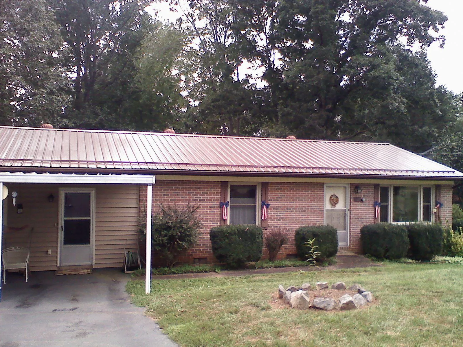 Bronze metal roof and carport on a brick ranch home — Roof Repair work by our crew in Fort Pierce