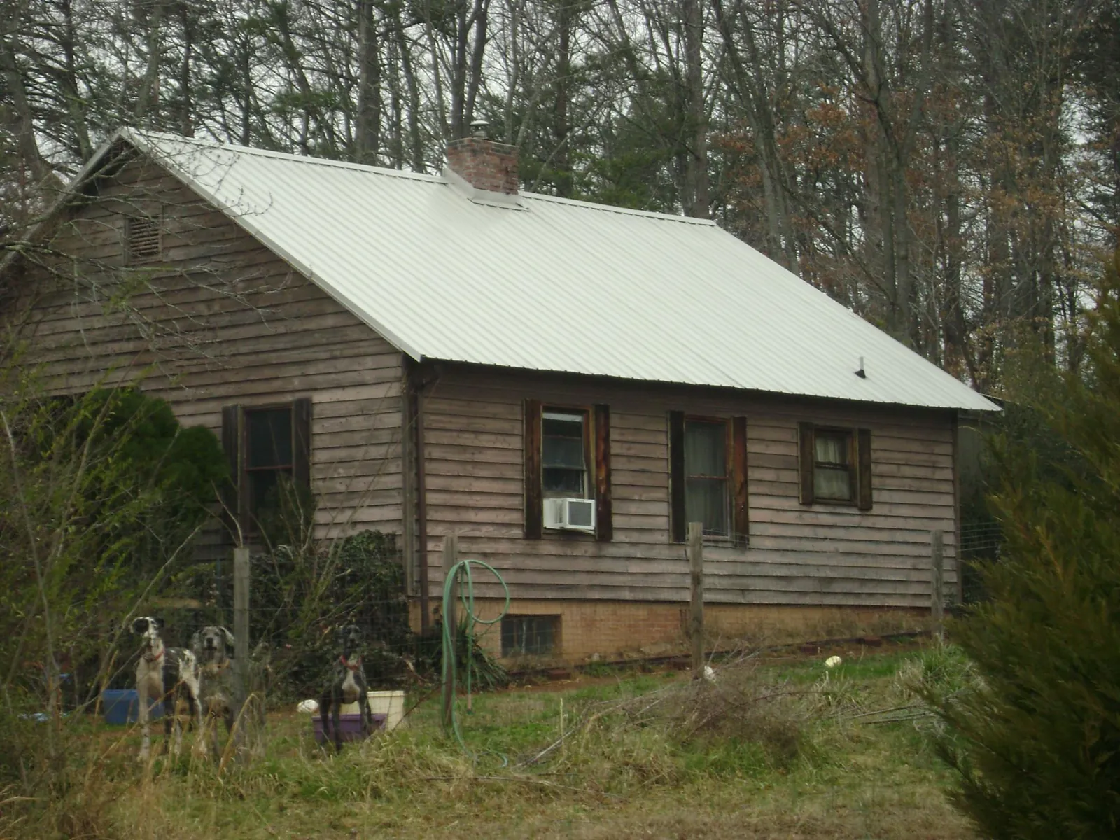 White metal roof on an old wood sided farmhouse, from a Metal Roof Installation job in Fort Pierce
